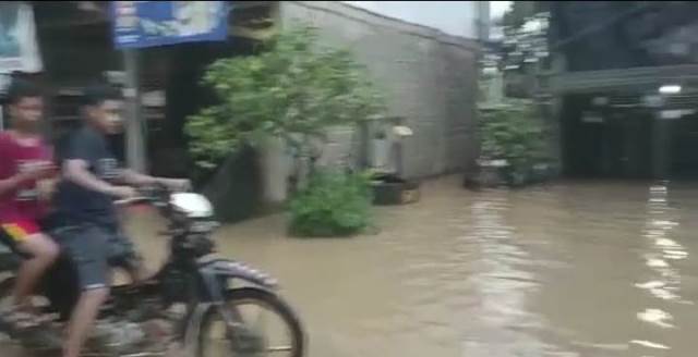 Dua bocah ini nekat menerobos banjir di Jalan Desa Pengaron Kecamatan Pengaron Kabupaten Banjar. (Foto: Katajari.com)