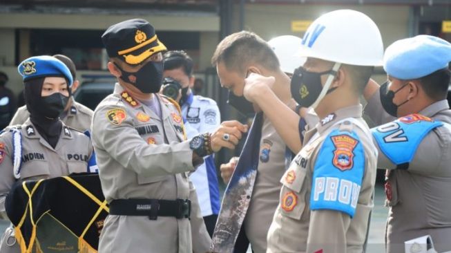 Kapolres Banjarmasin Kombespol Sabana melepas baju Bripka BT, Sabtu (29/1/2022). (Foto: Antara)