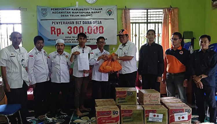 Kepala Pelaksana Badan Penanggulangan Bencana Daerah (BPBD) Kabupaten Banjar, Warsita, menyerahkan bantuan. (Foto: Kominfo Kabupaten Banjar)