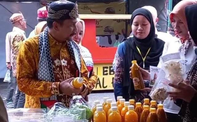 Pj Bupati Tanah Laut, Syamsir Rahman mencoba beberapa produk diproduksi oleh para Penerima Manfaat (PM) Program YESS. (Foto: Tim Ekspos SMK PP Negeri Banjarbaru/Katajari.com)