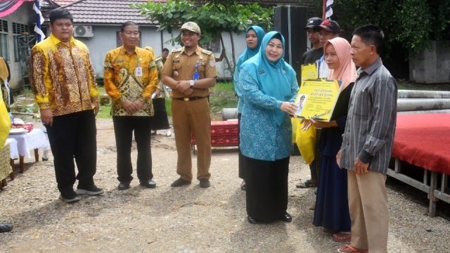 Ketua Tim Penggerak PKK Provinsi Kalimantan Selatan, Hj Raudatul Jannah Sahbirin menyerahkan bantuan penyambungan jaringan listrik masyarakat tidak mampu di Kecamatan Aluh-Aluh Kabupaten Banjar, Senin (11/12/2023) di depan Kantor Camat Aluh-Aluh. (Foto: Adpim Setdaprov Kalsel/Katajari.com)